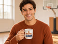 Basketball Season Is My Favorite Season Mug, Basketball Fan Coffee Mug, man in a rust sweater holding the mug in a sunny gym